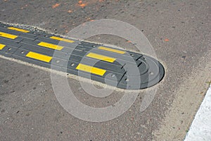 Traffic safety speed bump on an asphalt road. Speed bumps (or speed breakers)