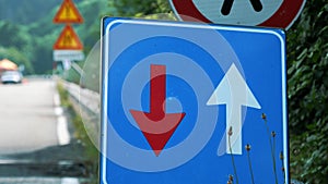 Traffic sign. blue square with red and white arrows. Road works sign. close-up. Repair work is underway on the road