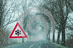 Traffic sign Caution Snowfall, slippery due to snow photo