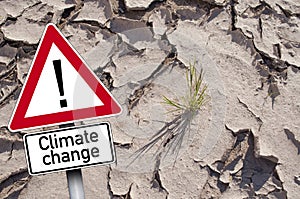 Traffic sign with climate change in front of dry ground