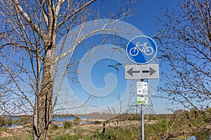 Traffic sign: cycle lane in both directions, blue and white round plate, cycle routes 4 and 13