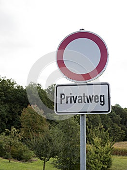 Traffic sign with German text `Privatweg` translates into `Private road` in English language