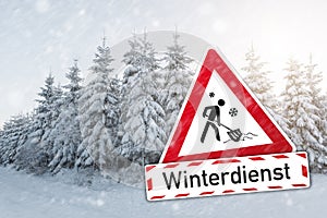 Traffic sign German word Winterdienst winter services for winter time with push snow icon and a winter forest photo