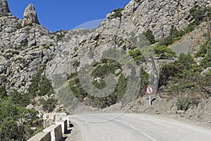 Traffic sign `Give way on oncoming traffic` at a dangerous turn on a mountain road.