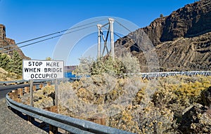 A traffic sign at the one-lane suspension bridge crossing the Deschutes River in Cove Palisades State Park, Oregon, USA