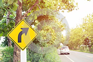 Traffic sign placed beside along the road on route twisty winding slope. background driver car