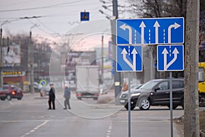 Traffic sign pointing multiple road lanes direction on city street. Signboard arrows for urban transport safety guidance
