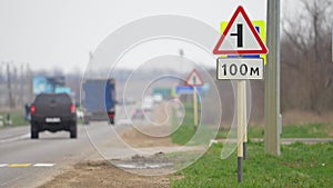 Traffic sign on the road. Crossroads. Cars drive on the road. Attention on the road while driving concept. Warning.