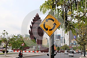 Traffic sign of roundabout and The Independence Monument, memorial Cambodian Independence Day after winning from the French