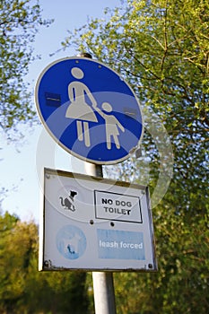 Traffic sign, sign, mother with child, pedestrian zone and the English words: no dog toilet, leash forced