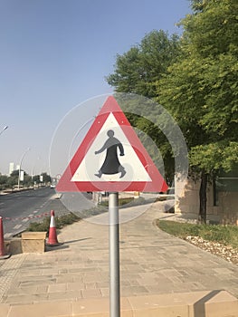 Traffic sign on a street in Doha, Qatar, showing a person in traditional Arabic dress