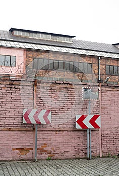 Traffic sign, wall made of bricks and factory