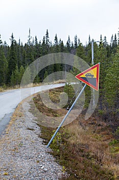 Traffic sign warning about high rise on a curvy road.