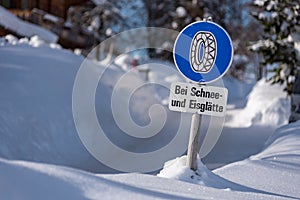 Snow chain obligation, Chain traffic sign. Winter time and winter services. Snow covered road, trees. Austria photo