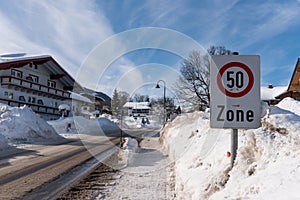 Traffic sign Speed zone 50 km/h. Warning, information sign near the winter road. Big snow around and mountains at the background photo