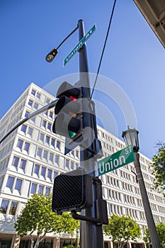 A traffic signal with a street sign that reads Union Street surrounded by lush green trees, a tall gray light post