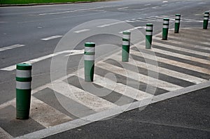 Traffic signs drawn on the road. zebra where he must not stop and park. striping on asphalt with the support of green plastic boll