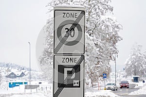 Traffic signs marking end of residential district, end of reduced speed zone of 30 km and end of parking zone in village Urdorf .