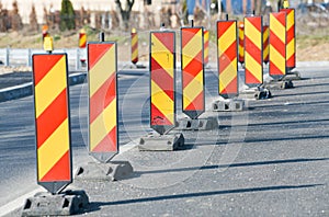 Traffic signs with orange and red colours used to deviate car traffic from a way to another