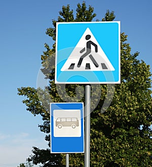 Traffic signs Pedestrian Crossing and Bus stop on city street