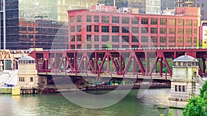 Traffic and trains are crossing a bascule bridge over the Chicago River.