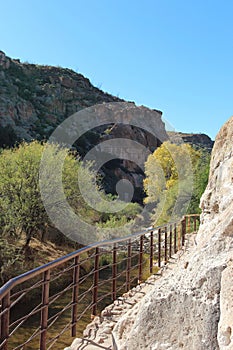 A trail carved into a mountainside along a creek in the mountains of the Sonoran Desert