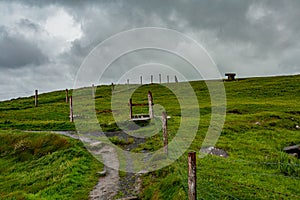 Trail with a dolmen in the background in the coastal route walk from Doolin to the Cliffs of Moher