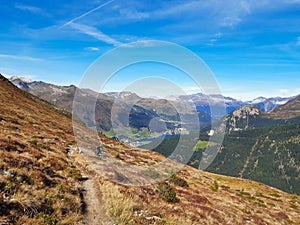 Trail for hiking or mountain biking enduro ride at Davos with view of lake of Davos, at autumn time, grison, Switzerland