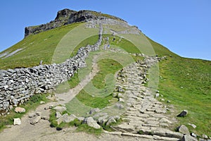 Trail on hill slope under clear blue sky