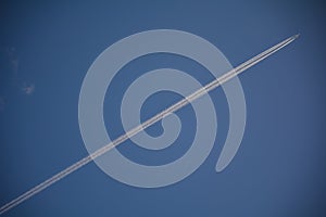 Trail of a jet plane in the blue sky