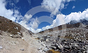 Trail in the Lobuche valley with big clouds and blue sky, Everest Base Camp trek, Nepal