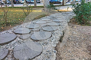 A trail made from transverse trimmings of tree trunks concreted in cement mortar. Landscaping of park areas in cities photo