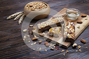 A trail mix bowl of dried fruit, raisins, cranberry with almonds, raisins, seeds, cashew, hazelnut nuts with honey. Vegetarian fit