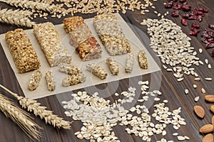 Trail mix, Cereal granola bars, sunflower seeds, raisins and wheat sprig on wooden background