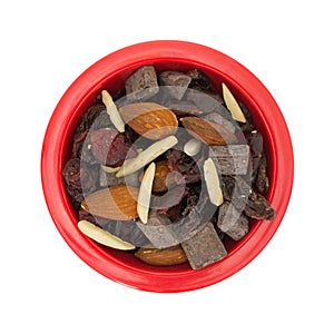 Trail mix with nuts and dried fruit in red bowl
