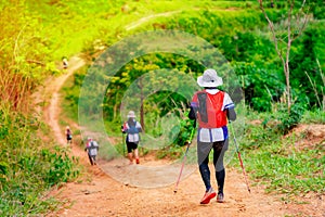 Trail runner, Asian woman wearing sportswear and equipment Practicing running and on a high mountain, running on a dirt path On a