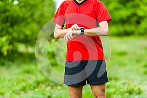 Trail runner looking at sport watch