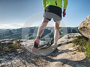 Trail runner in natural terrain, body contour in low ankle view photo