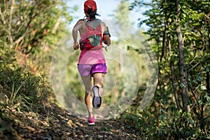 Trail runner running in forest trail