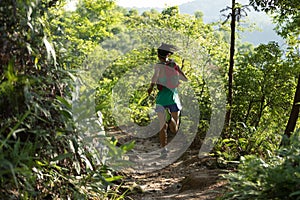 Trail runner running in morning forest