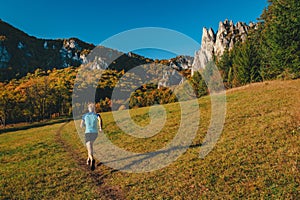 Trail runner train in beautiful autumn landscape. Carpathian forest and rocky hills in background