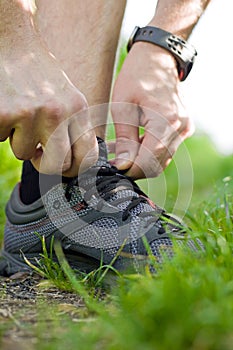 Trail runner tying shoe, running concept