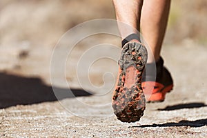 Trail running athlete exercising for fitness and health outdoors on mountain pathway