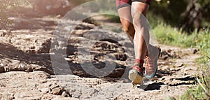 Trail running athlete exercising for fitness and health outdoors on mountain pathway