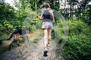 Trail running athletic woman in green forest, sports inspiration