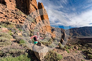 Trail running girl with backpack in mountains on rocky path