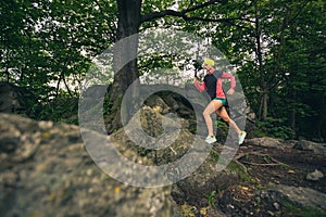 Trail running girl in green forest. Endurance sport. photo