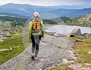 Trail running woman cross country in mountains on summer beautiful day