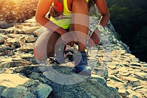 Trail running woman runner tying shoelace