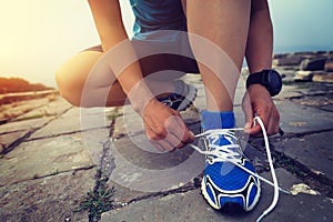 Trail running woman runner tying shoelace